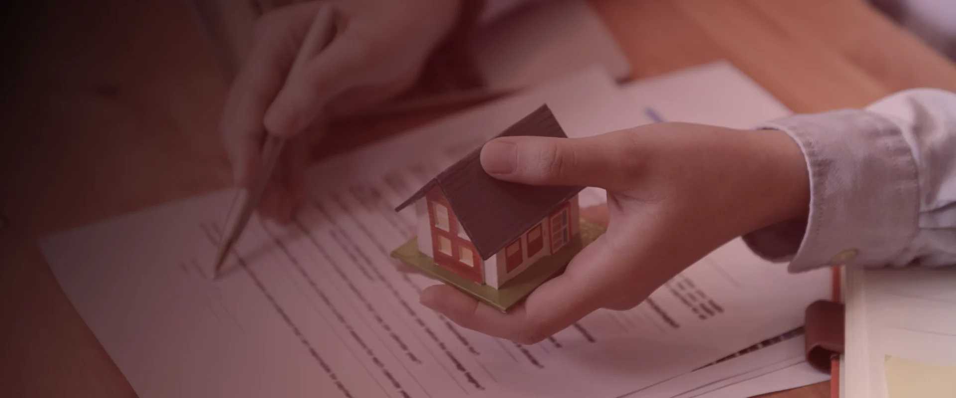 home inspector explaining inspection report to client and holding small house scale model valencia pa